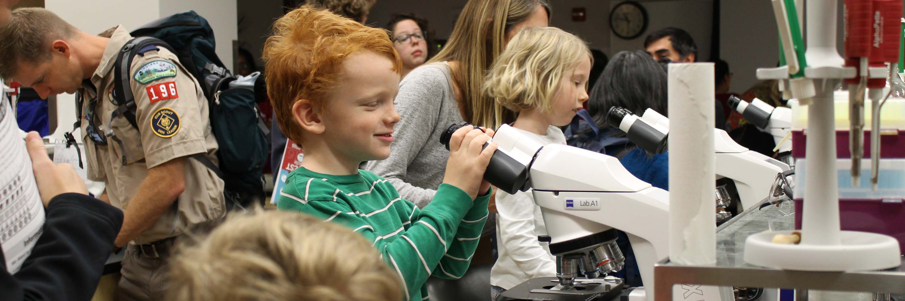 children and students interact during a science event