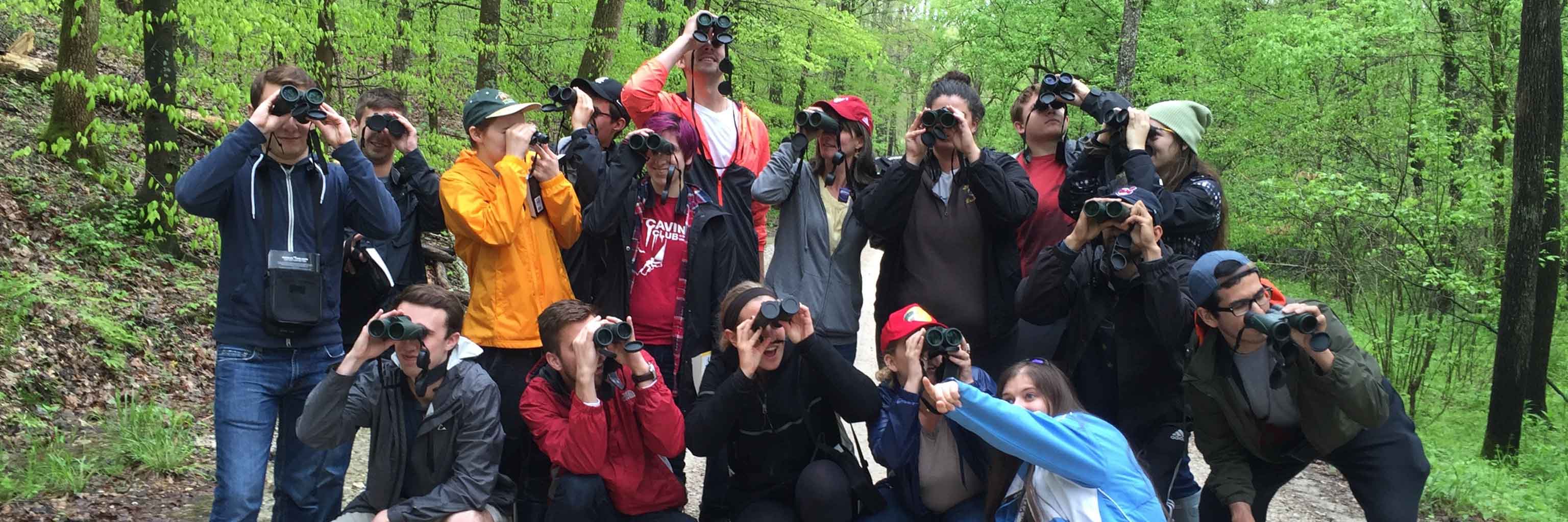 A group of students using binoculars