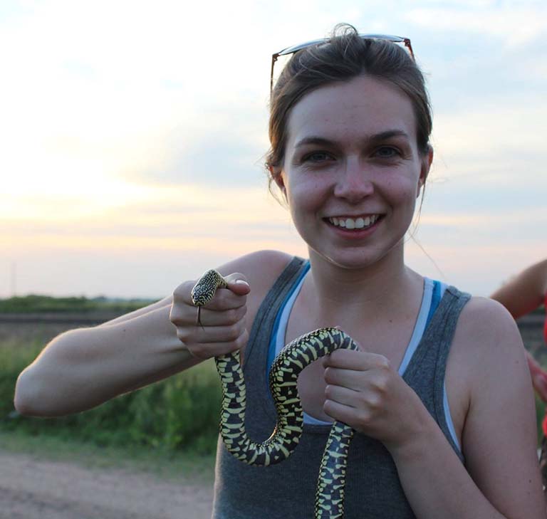 The snake sticks out its tongue as Emmi Mueller holds it up for the picture.