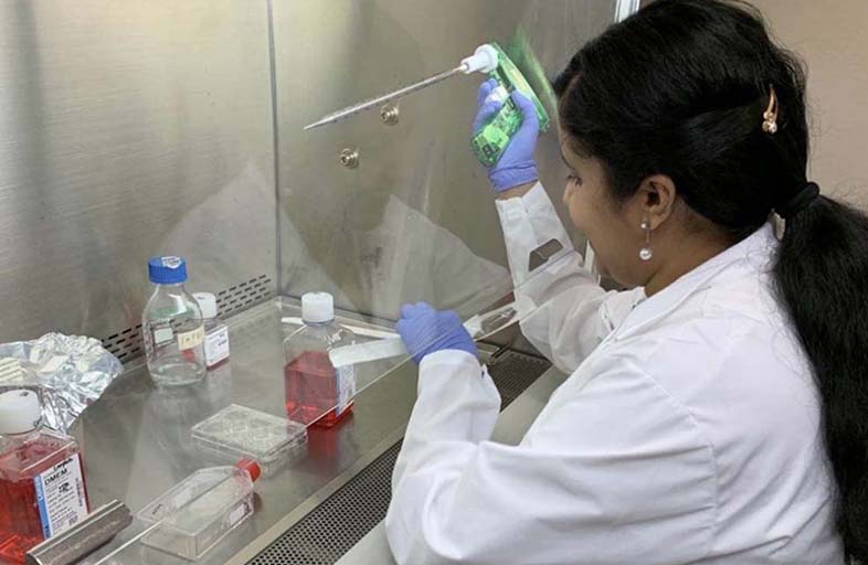 Asha Philip working at hood in lab.