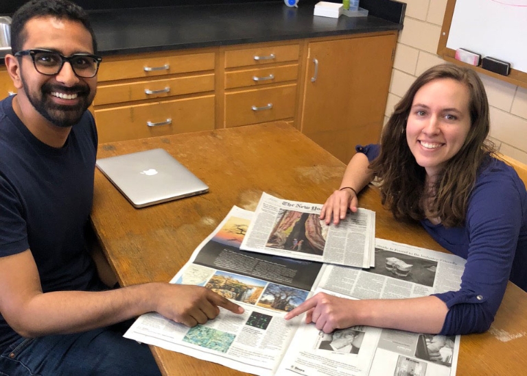 Ankur Dalia and Courtney Ellison point to the article about their research printed in The New York Times on June 19, 2018.