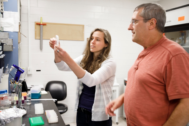 IU Ph.D. student Courtney Ellison examines a petri dish in the lab with Yves Brun, IU Distinguished Professor of Biology.