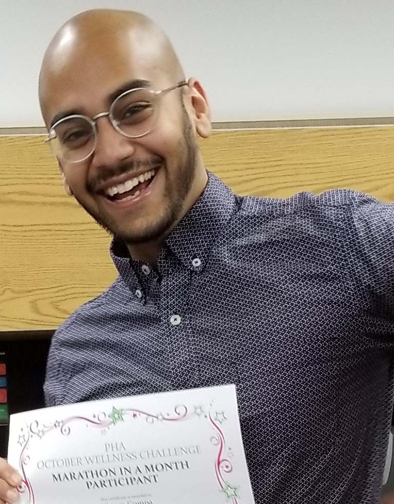 Shawn Gompa displaying his "Marathon in a Month" certificate.