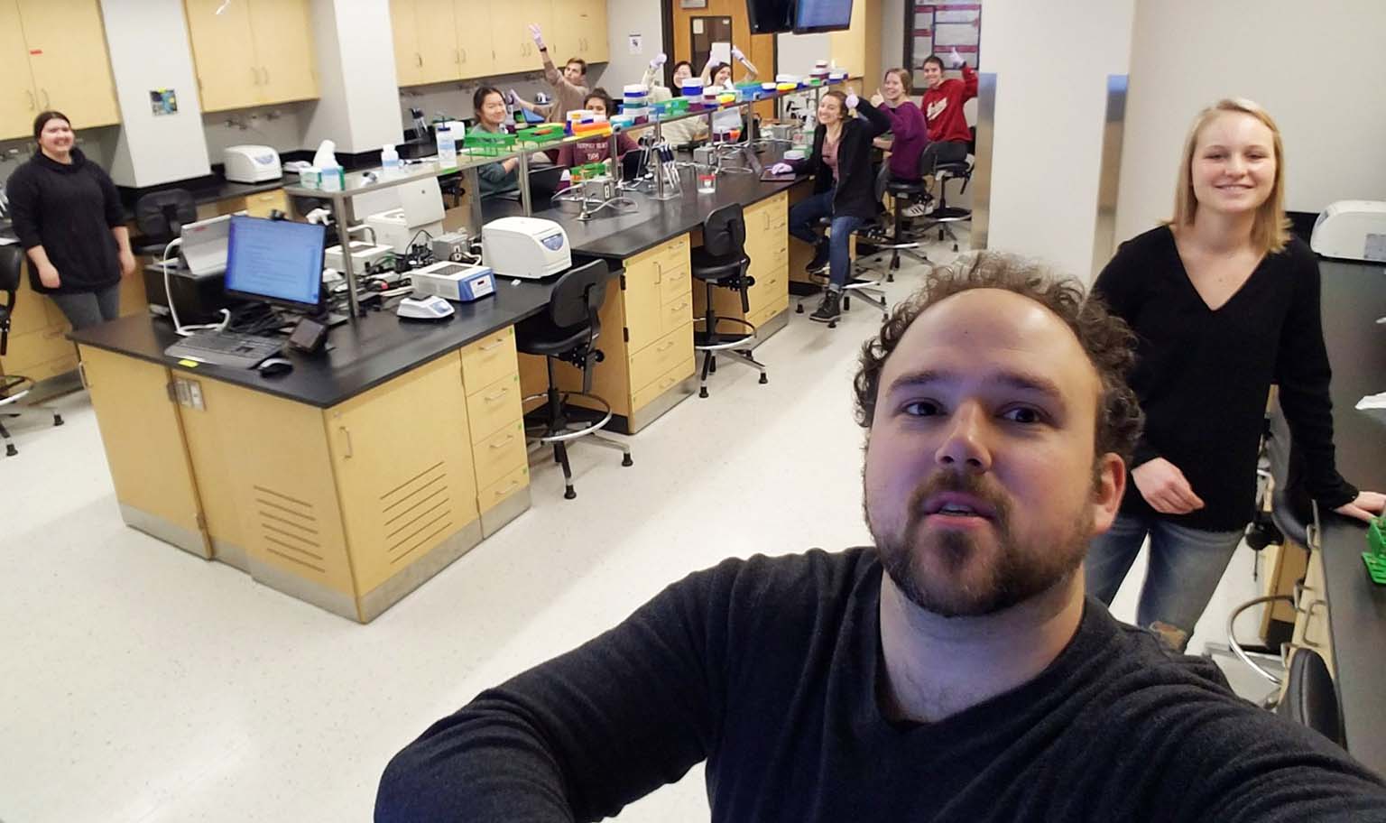 Instructor Mike Manzella takes a selfie of himself and his lab full of students.
