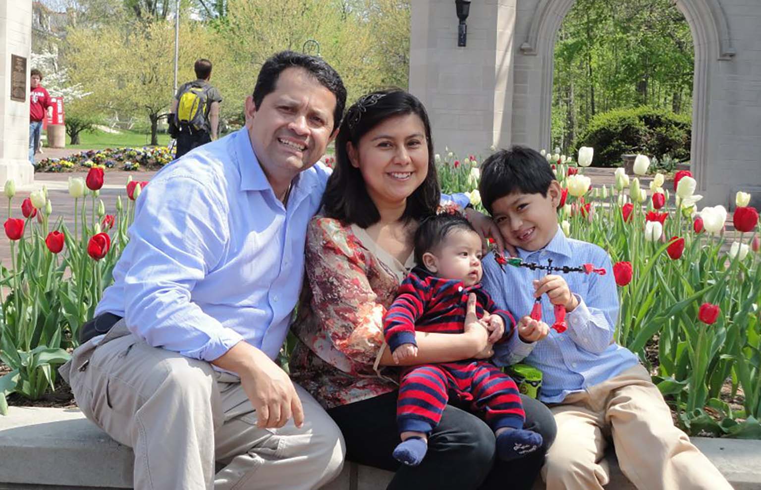 Jessica Duchicela and family pose for photo in front of Sample Gates on the IU Bloomington campus during graduation 2013.