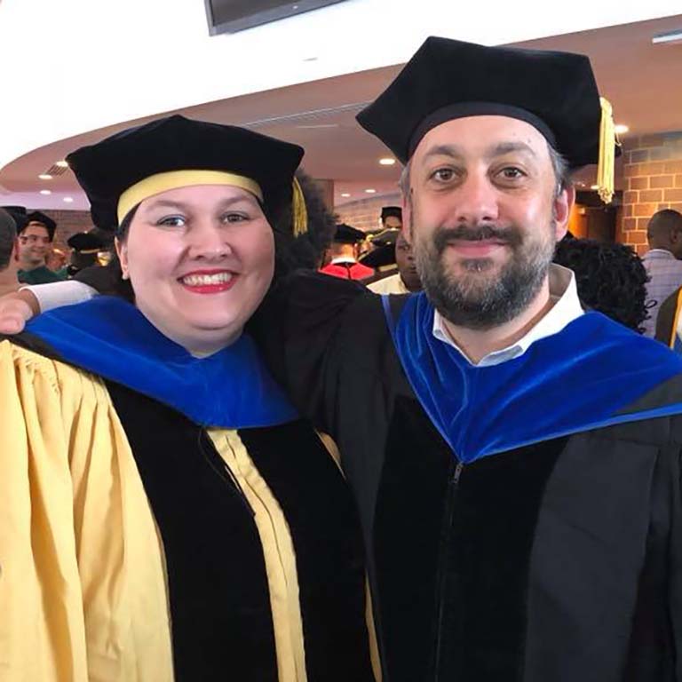 Gabrielle Sell in black and gold graduation garb poses with her Ph.D. mentor Seth S. Margolis at Johns Hopkins University.