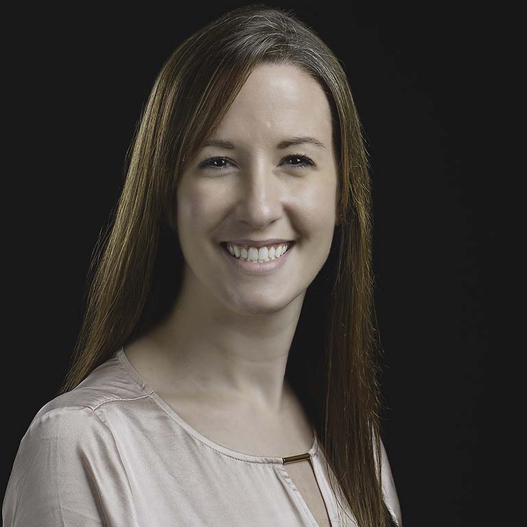 Julia van Kessel--a white woman with long, straight, brown hair--smiles for the portrait photo.